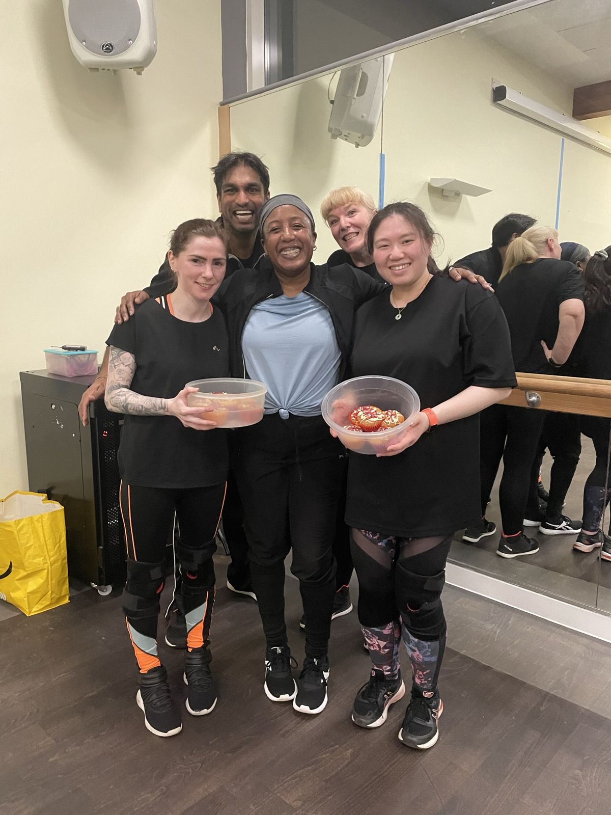 Medina with class members holding cupcakes to celebrate after class