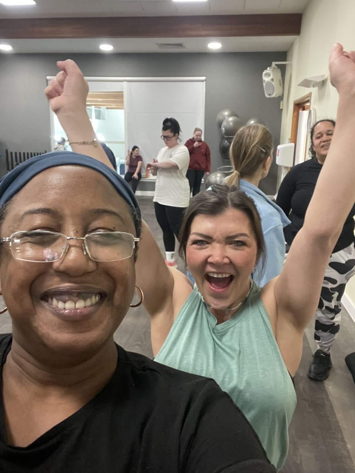 Medina and a class member with arms raised mid-celebration