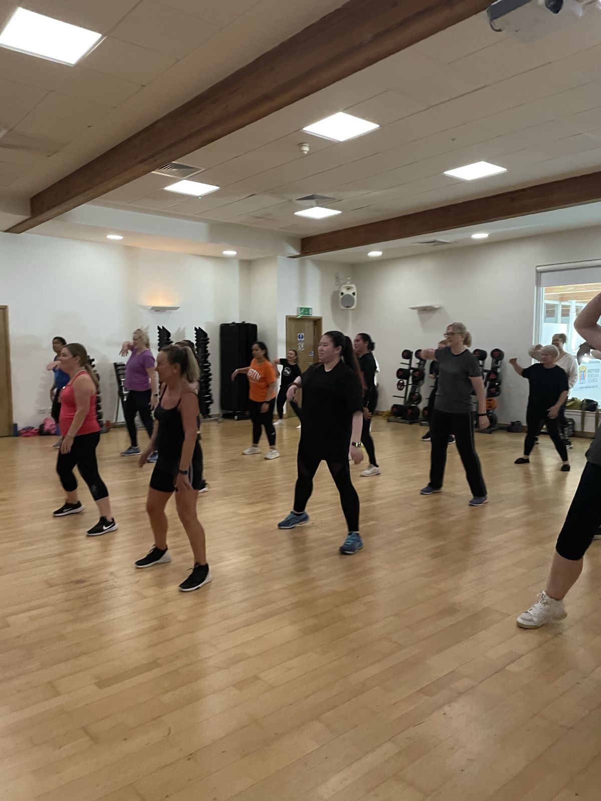 Medina leading a dance fitness class, members following the routine