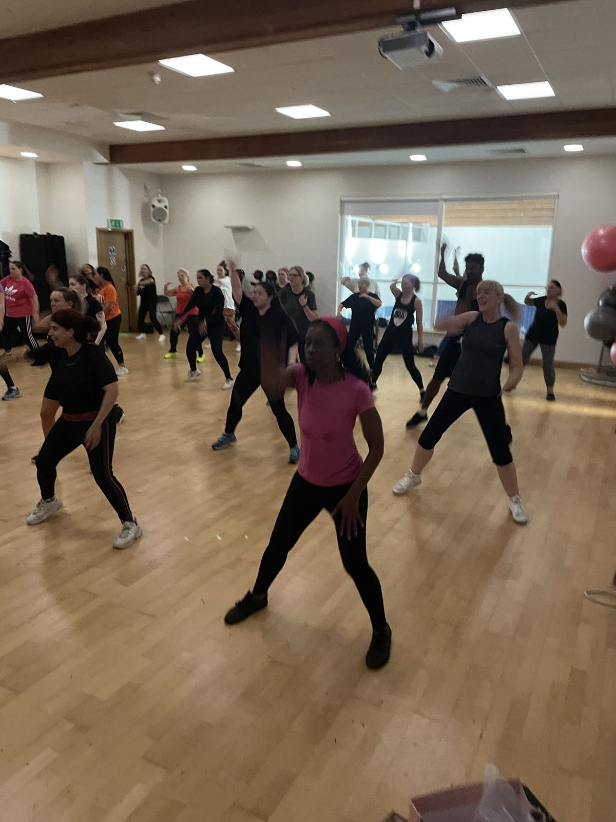 Class members dancing mid-routine in a large studio